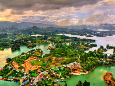 Aerial view of Guatapé, Colombia at sunset, showcasing its vibrant landscapes lush green hills and a network of shimmering turquoise lakes