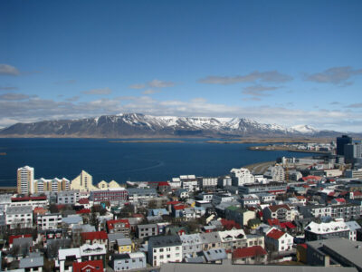 high-angle-view-townscape-by-sea-with-snowcapped-mountains-background