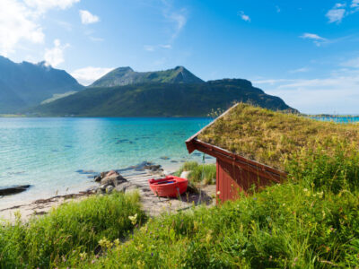 red rowing boat at a beautiful blue fjord on the Lofoten islands in Norway