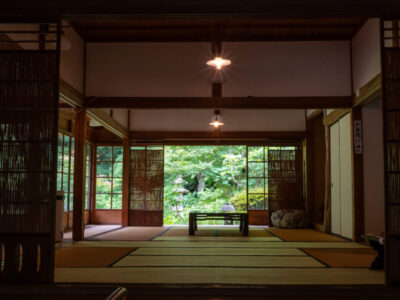 Traditional tatami room at Jochi-ji Temple in Kamakura, Japan opens to a lush green garden, blending indoor simplicity with natural beauty